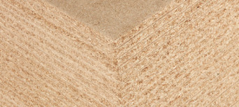 Detailansicht einer Spanplatte mit feiner Holzspanstruktur, ideal für Möbelbau und Innenausbau.