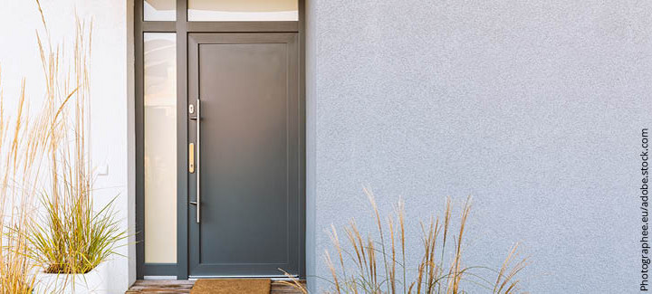 Graphitfarbene Eingangstür eines Hauses mit seitlichen und oberen Glaselementen für zusätzliches Licht.