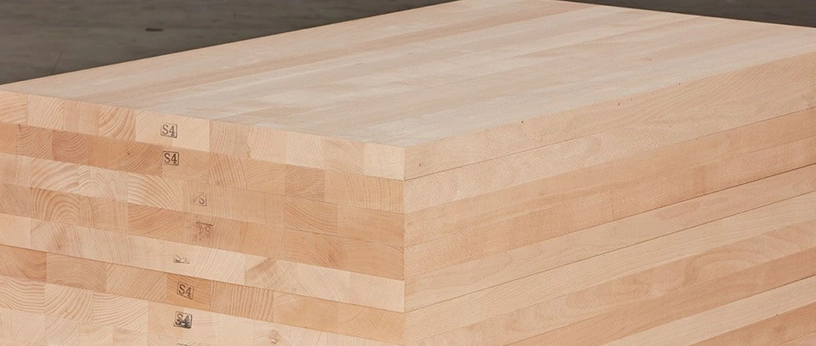 Gestapelte Massivholzplatten mit durchgehenden Lamellen, ideal für den Möbel- und Innenausbau.