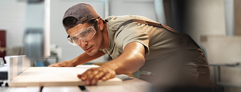 Holzzuschnitt - Abbildung Mann an Säge