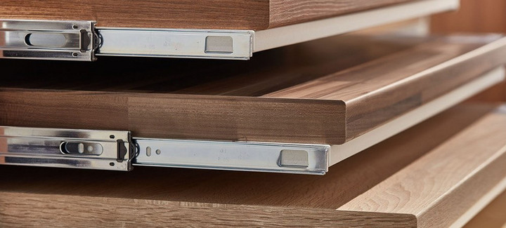 Gestapelte Holzarbeitsplatten mit Metallschienen, ideal für Küchen- und Möbelbau.