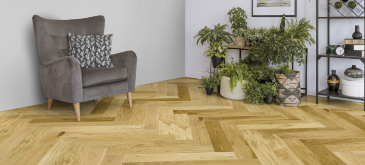 Wohnbereich mit hellem Fischgrätenparkett ausgelegt.