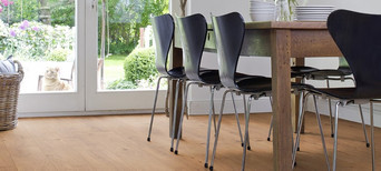 Das Esszimmer ist mit Laminat in hellem Holzfarbton ausgelegt. Ein massiver Esstisch aus Holz und leichte Stühle runden die Einrichtung ab.