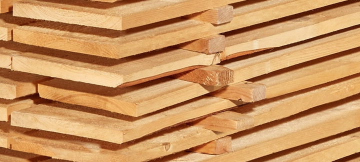 Gestapelte Schalbretter aus Holz mit sägerauer Oberfläche, ideal für den Bau- und Konstruktionsbereich.